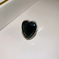 Dettaglio di un anello a cuore in argento con una grande pietra verde smeraldo sfaccettata - Argento Nero