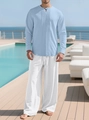 Herren-Set aus hellblauem Baumwoll-Leinen-Hemd und weißer Hose auf einer Resort-Terrasse - Hellblau + Weiß