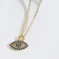 Makroaufnahme des Evil Eye Anhängers mit blauen Kristallen und vergoldeter Metalltextur - Goldenes Königsblaues Zirkon Böses Auge