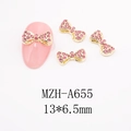 Dettaglio charm per unghie a fiocco con strass rosa, base dorata e dimensioni 13x6,5mm - Fiocco Lungo (A655)