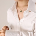 Collana vintage dorata con ciondolo ovale in smalto verde e fiore bianco su una modella - Collana d'Oro Smalto Margherita (40+5cm)