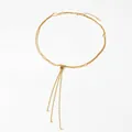 Collier en Y doré à double épaisseur avec nœud décoratif et trois chaînes à pompons - Doré