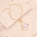 Close-up of golden butterfly bracelet with iridescent purple and pink pendants on stone - White (7#)