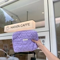 Close-up of light purple quilted makeup bag with heart patterns and brand label - Purple Heart