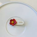Detailed macro view of handmade flower hair clip with France Handmade text on resin base - White Clip with Small Red Flower