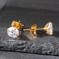 Detailed macro view of a 6mm round cubic zirconia stud earring with four-prong gold setting - 6mm / Gold