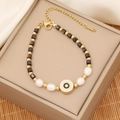 Detailed view of evil eye beaded bracelet with gold accents and lobster clasp - Black