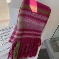 Pink and green striped mohair scarf with tassels displayed on a white chair - Plum