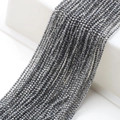 Dettaglio macro di perline sfaccettate in vetro grigio scuro da 2mm per gioielli fai da te - Bianco K/Argento