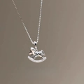Gros plan détaillé d'un collier pendentif cheval à bascule argenté serti de zircons - Style Cheval à Bascule Entièrement Serti de Zircon / Argenté
