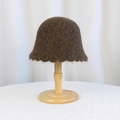Plush dark brown knitted bucket hat for women on a wooden stand with a soft finish - Coffee