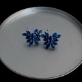 Detail of blue crystal butterfly earrings on a silver plate with sharp gemstone texture - Blue
