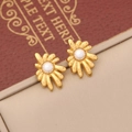 Detaillierte Makroansicht goldener Blumenohrstecker mit mittigen weißen Perlen - Ohrringe