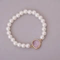Macro view of white faux pearl bracelet featuring a pink gemstone pendant with gold trim - Pink