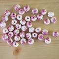 Detail view of round white ceramic beads with pink flower patterns for DIY jewelry making - No.36-Pink Floral