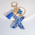 Royal blue resin letter X keychain with tassel, butterfly charm and gold flakes - Letter X