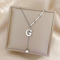 Detail of silver G-letter pendant on punk style stainless steel chain in a jewelry box - Silver