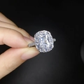 Macro shot of a silver ring with a square-cut gemstone and brilliant halo diamonds - Adjustable Open / White Stone White Gold