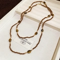 Détail du collier ethnique en perles d'œil de tigre avec entretoises sur plateau velours - Marron