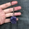 Handheld view of a raw purple amethyst crystal keychain with silver metal ring - Lilac Stone