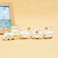 Vista lateral del tren navideño de madera en blanco y dorado con figuras festivas - Blanco