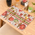 Christmas knitted placemat with red reindeer and green holly patterns on a wooden table - Christmas Reindeer Style
