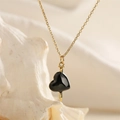 Makroaufnahme der vergoldeten Kette und des schwarzen Herzanhängers mit Nageldetail - Gold-Schwarzes Herz mit Nagel