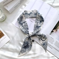Detailed close-up of a blue Toile de Jouy print silk twilly scarf on white linen - Sketch Spring Letter C