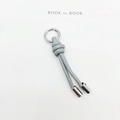 Detail of grey-blue braided leather keychain with silver spring clasp and metal caps - Gray