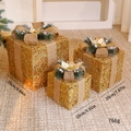 Three-piece gold glitter Christmas gift boxes with burlap bows and pine needle accents - Gold Sparkling Gift Boxes 3Pcs