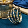 Macro detail of dual-tone gold and silver coiled snake bracelet with bamboo texture - Black Gold Silver Mixed