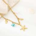Detailopname van gouden ketting met zeester, schelp en visbedels op een steen - Zeester Schelp Charm Stijl (KN292178-SXSJ)