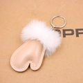 Dettaglio del ciondolo a cuore in pelle nude con portachiavi a pompon in pelliccia bianca - Albicocca