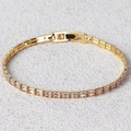 Bracelet doré élégant avec zircons roses rectangulaires sur fond de texture de roche - Doré
