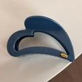 Close-up of blue hollow heart-shaped hair claw with gold Love plate detail - Heart-Shaped / Blue