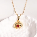 Détail du pendentif coccinelle avec cristal rouge sur une chaîne en acier titane doré - Or Zirconium Rouge