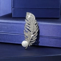 Close-up of elegant feather brooch with crystal pavé and large white pearl on silk gift box - Silver Feather Pearl