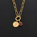 Collana in acciaio inossidabile dorato con lettera V di strass e ciondolo con gemma rossa - Lettera V / Oro