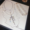 Détail d'un ensemble de collier et bracelet en perles avec pendentif croix en strass - Set de 2 pièces / Argent