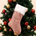 Pink sequin Christmas stocking with white faux fur cuff hanging on a decorated festive tree - Rose Gold