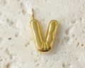 Close-up of a polished golden bubble letter V pendant on a textured stone surface - Letter-V / Steel