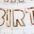 Close-up of rose gold Happy Birthday banner letters with reflective metallic foil finish - Mirror Paper Hollow Rose Gold