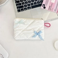 Quilted white cosmetic bag with blue bows and pink loop on a minimalist desk setting - Creamy White Plaid