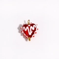 Detail shot of a handmade red glass heart pendant with white patterns and gold loop - Red Base White Pattern (Style 5)