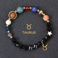 Close-up of Taurus constellation bracelet with cosmic planet beads and golden charm - Taurus