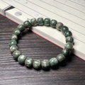 Green Xingyue Bodhi seed bracelet with 21 polished beads on vintage book background - Star Moon Green Skin Old Style
