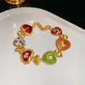 Détail d'un bracelet doré de style vintage avec des cœurs émaillés multicolores et gemmes - Bracelet-Or-Multicolore