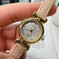 Women's quartz wrist watch with beige leather strap and gold case in a hand-held view - Apricot