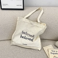 Detail der beloved Stickerei auf cremefarbenem Canvas-Shopper mit fester Textur - Dunkelblau