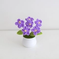 Close-up of five purple crocheted flowers in a white ceramic pot with green leaves - Forget-me-not - Purple